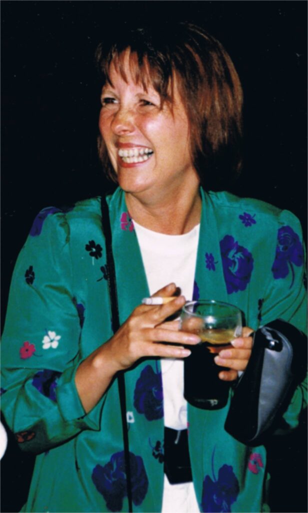 lachende Sabine Wickel mit Getränk in der Hand